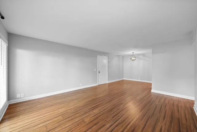 a view of a room with wooden floor and a ceiling fan