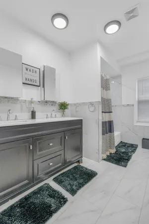 a spacious bathroom with a granite countertop sink a toilet a mirror and shower