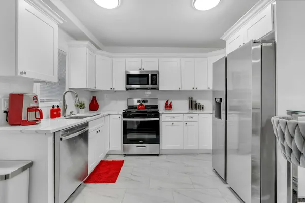 a kitchen with stainless steel appliances kitchen island granite countertop a refrigerator and cabinets