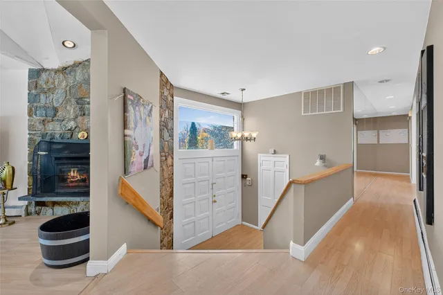 a kitchen with kitchen island a stove a sink a dining table and chairs with wooden floor