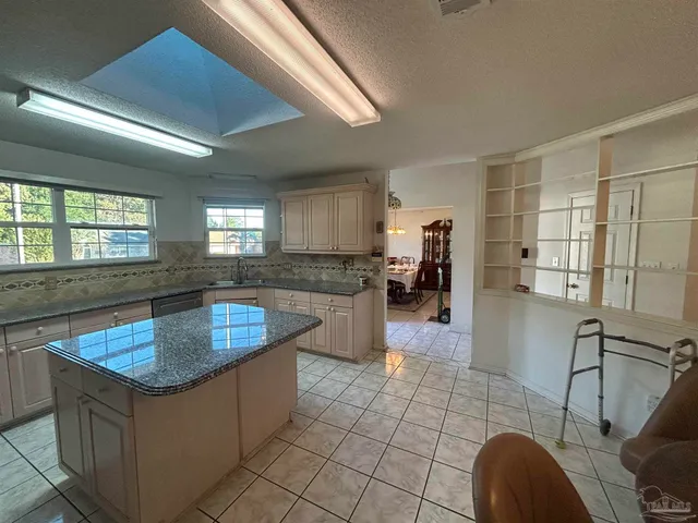 a kitchen with stainless steel appliances granite countertop a sink a counter top space and a window