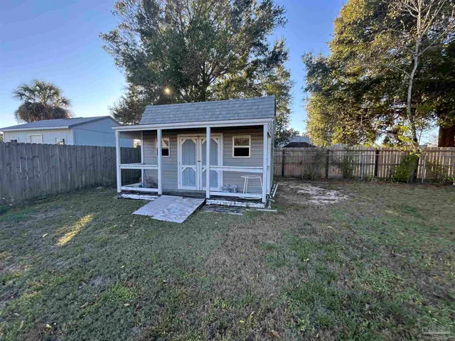 a view of a yard in front of a house with large tree