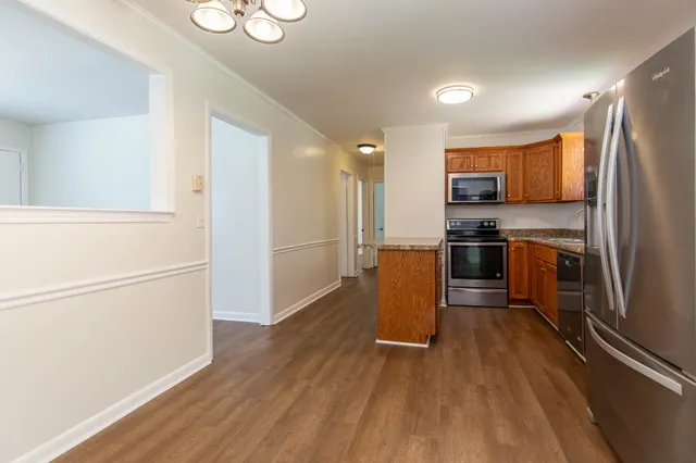 a kitchen with stainless steel appliances a refrigerator and wooden floor