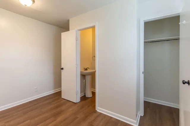 an empty room with wooden floor and entrance