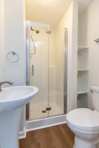 a bathroom with a sink a toilet and shower