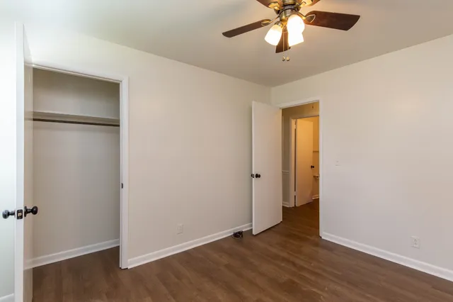 a view of an empty room with window and wooden floor