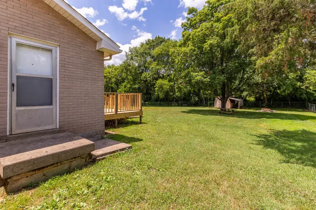 a view of a house with backyard and trees