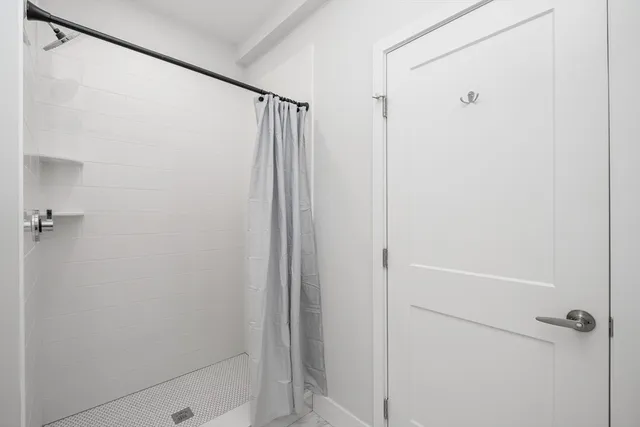 a bathroom with a shower and a glass shower door