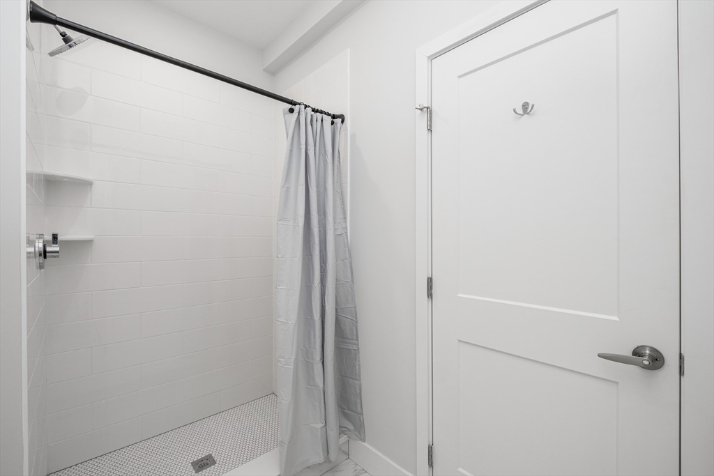 1540 North Shore Road, Unit 202 Revere, MA 02151 - Photo 12 of 19 a bathroom with a shower and a glass shower door