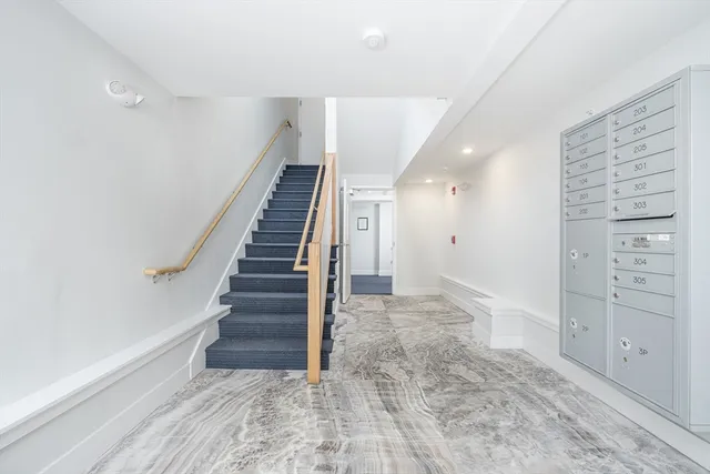 a view of hallway with stairs and wooden floor