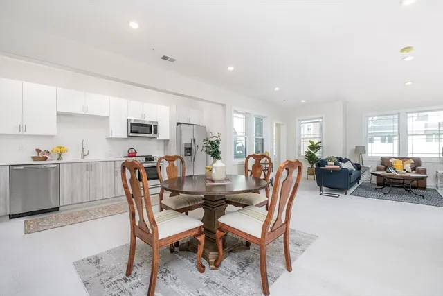 a dining room with furniture and a view of kitchen