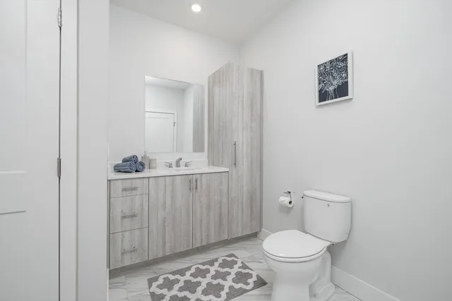a bathroom with a toilet sink and mirror