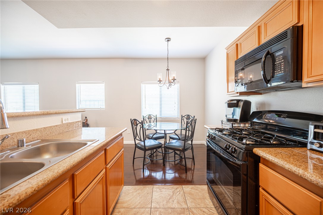 7701 West Robindale Road, Unit 274 Las Vegas, NV 89113 - Photo 16 of 43 Granite counters and rich wood cabinetry define this well-appointed kitchen with an adjacent dining area.