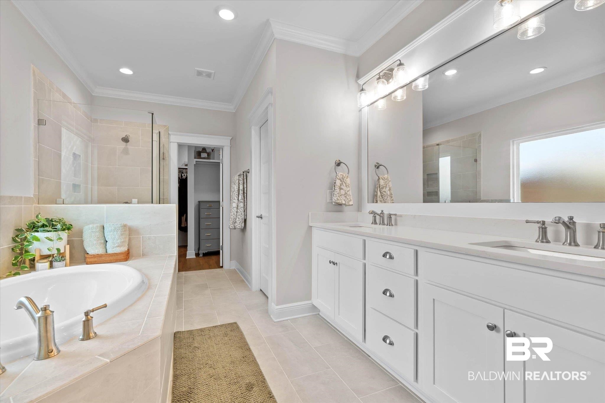 23523 Travis Stock Street Foley, AL 36535 - Photo 17 of 45 Contemporary bathroom featuring a spacious built-in soaking tub, a tiled walk-in shower with glass enclosure, a dual vanity with white cabinetry, and recessed lighting