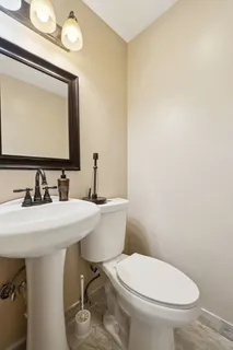 a bathroom with a toilet a sink and mirror
