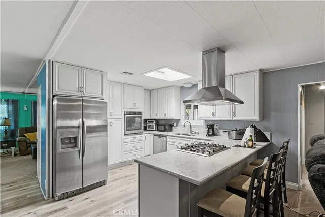 a kitchen with kitchen island a refrigerator stove and sink