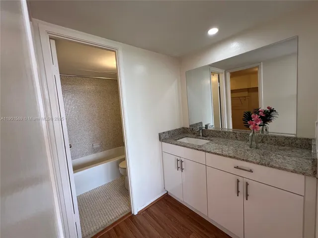a bathroom with a granite countertop sink and a mirror