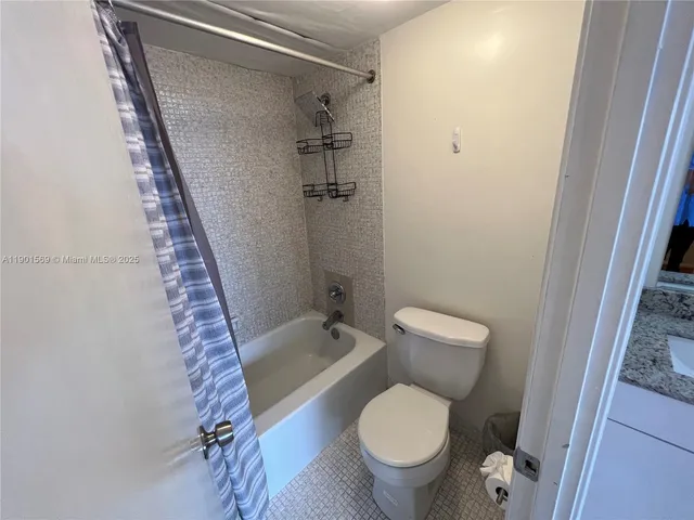 a white toilet sitting next to a bath tub