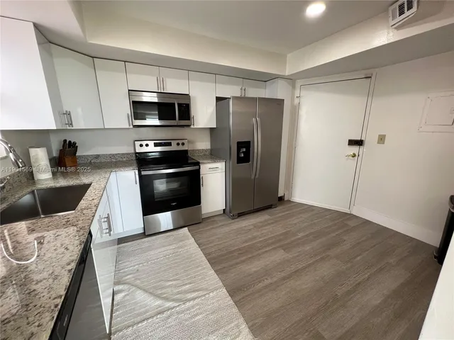 a kitchen with stainless steel appliances granite countertop a refrigerator stove and sink