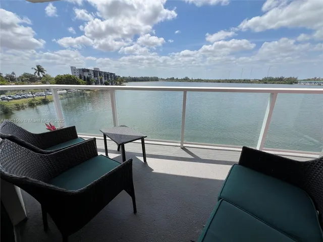 a view of a lake from a balcony with seating space