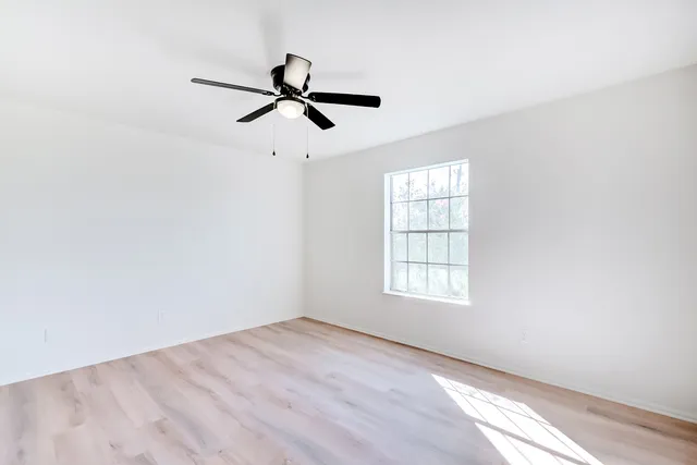 an empty room with closet and windows
