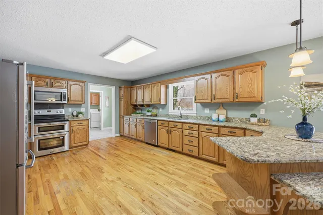a kitchen with stainless steel appliances granite countertop a stove sink and cabinets
