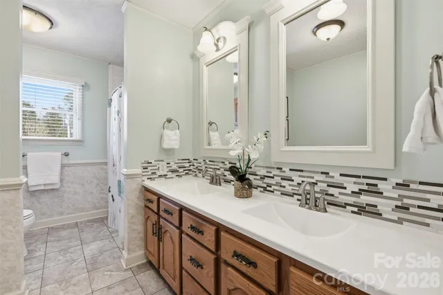 a bathroom with a sink double vanity granite tub shower and a mirror