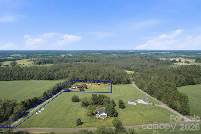 a aerial view of a house in middle of the green field