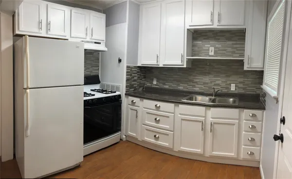 a kitchen with white cabinets and white appliances