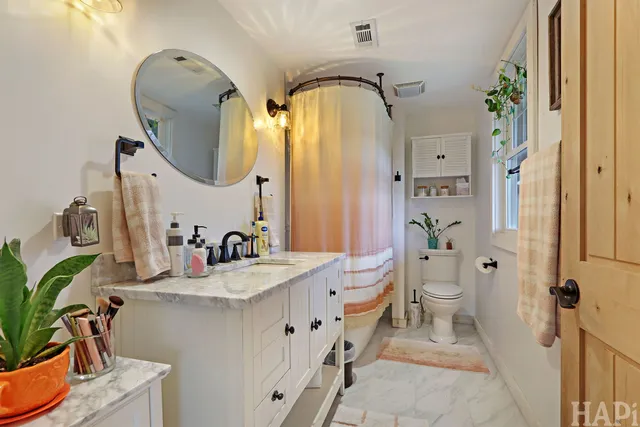 a bathroom with a double vanity sink mirror and toilet