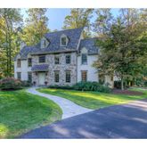 a view of a big house with a big yard and large trees