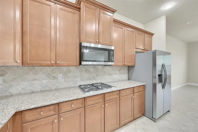 a kitchen with stainless steel appliances granite countertop a refrigerator sink and cabinets