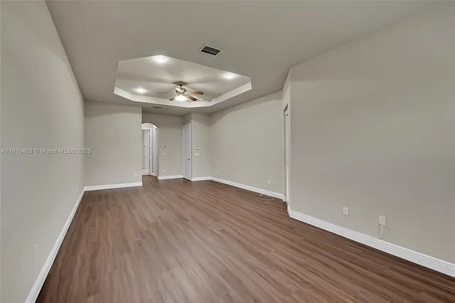 a view of empty room with wooden floor