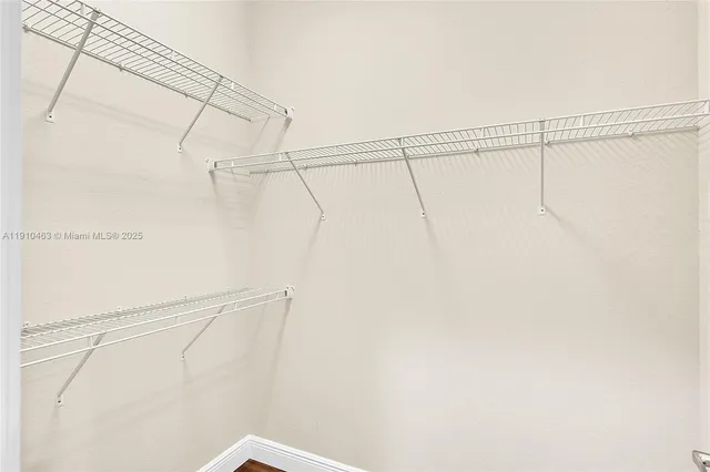 a view of a room with wooden floor and a ceiling fan