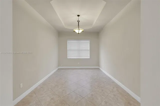 an empty room with windows and chandelier