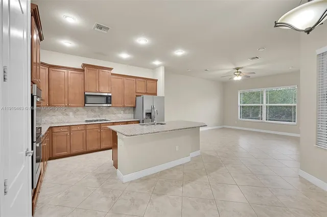 a large kitchen with kitchen island a sink stainless steel appliances and cabinets