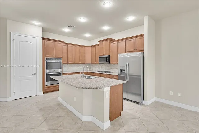 a kitchen with stainless steel appliances granite countertop a refrigerator sink and cabinets