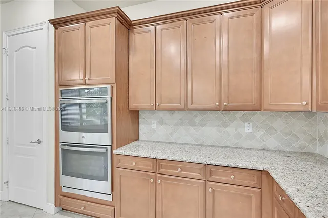 a kitchen with granite countertop a refrigerator and cabinets