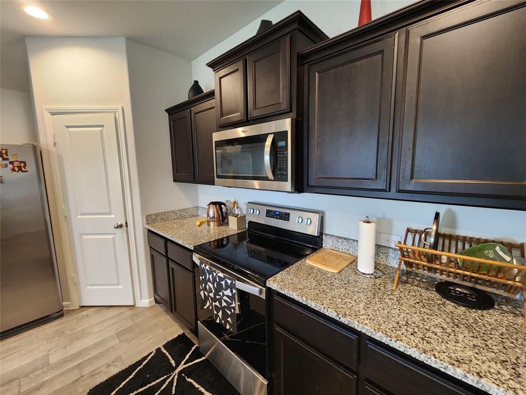 9240 Castorian Drive Fort Worth, TX 76131 - Photo 14 of 40 a kitchen with granite countertop a sink and a stove top oven