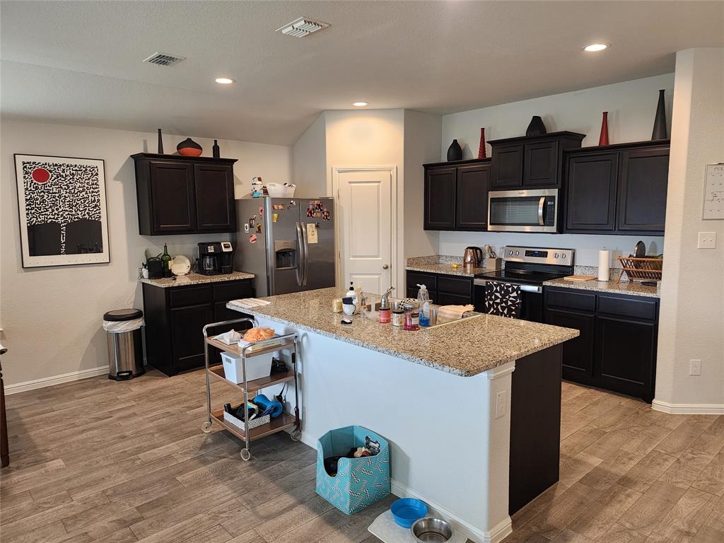 9240 Castorian Drive Fort Worth, TX 76131 - Photo 20 of 40 a kitchen with kitchen island a sink stove and refrigerator