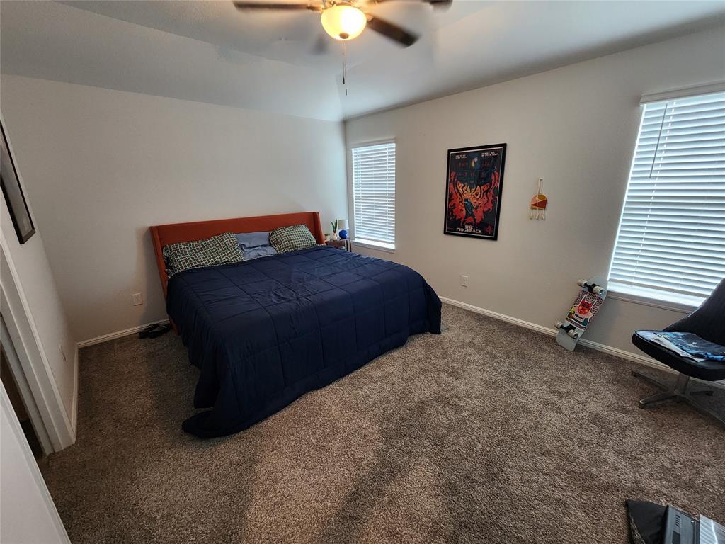 9240 Castorian Drive Fort Worth, TX 76131 - Photo 21 of 40 a bedroom with a bed and a chandelier