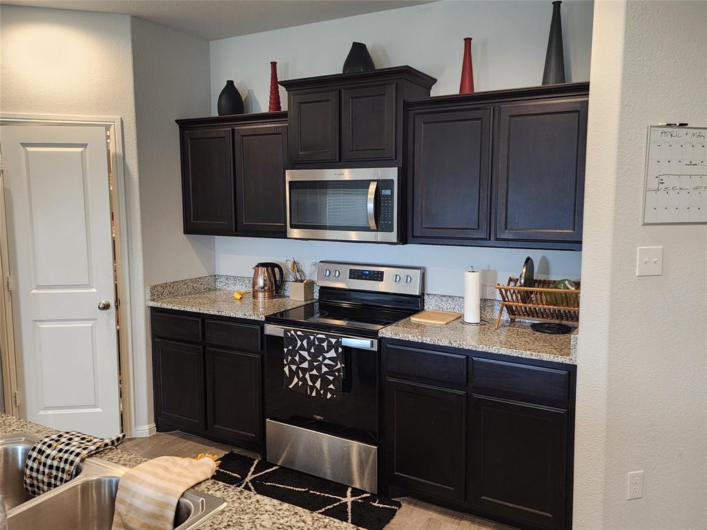 9240 Castorian Drive Fort Worth, TX 76131 - Photo 35 of 40 a kitchen with granite countertop a stove and a microwave