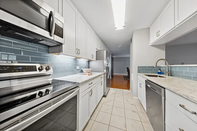 a large kitchen with stainless steel appliances granite countertop a stove and a sink
