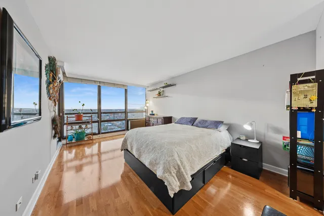 a spacious bedroom with a bed and a view of kitchen