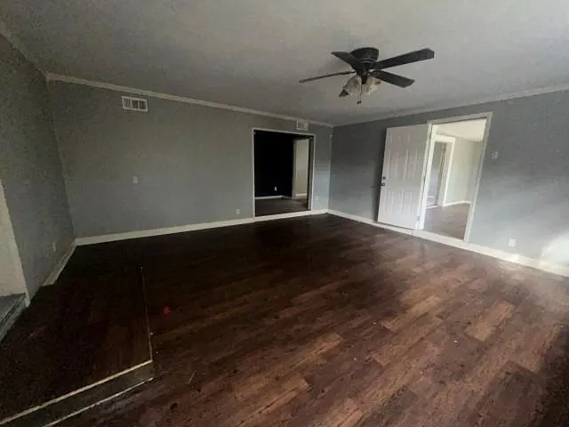 a view of room with wooden floor and a ceiling fan