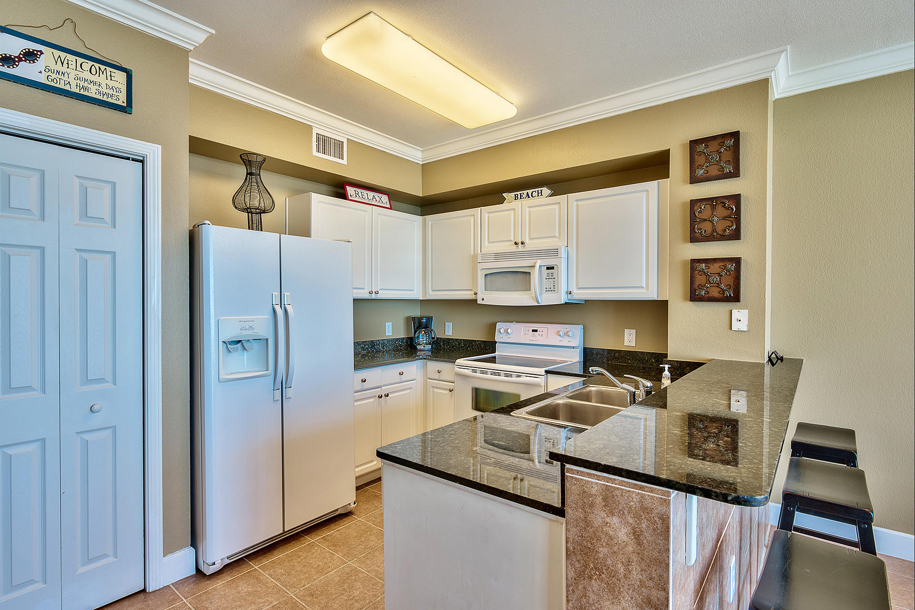 16819 Front Beach Road, Unit 1110 Panama City Beach, FL 32413 - Photo 3 of 34 a kitchen with a refrigerator and a stove top oven
