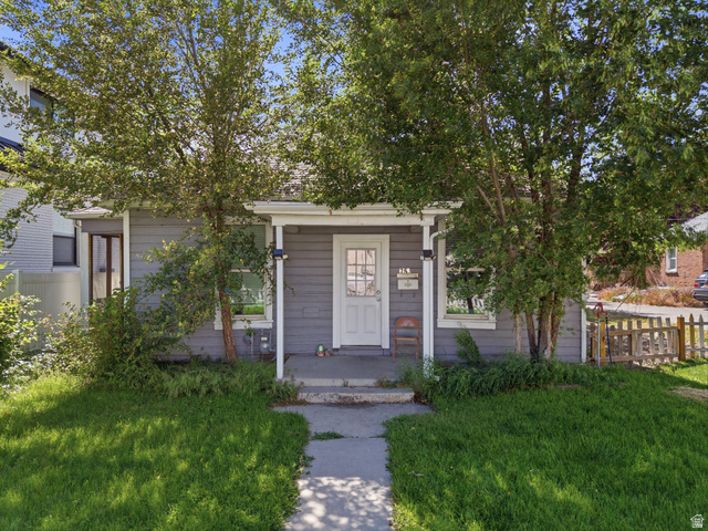 75 600 West Provo, UT 84601 - Photo 1 of 26 Gray exterior siding with white trim, featuring a covered front porch and a white entry door