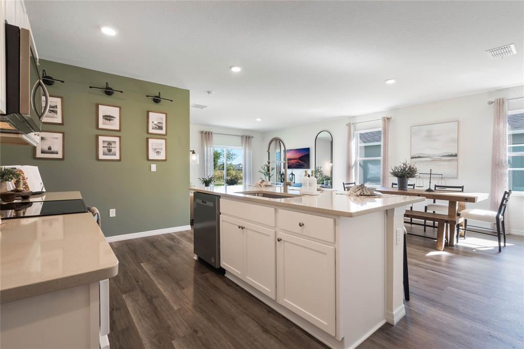 3441 Nettle Loop Tavares, FL 32778 - Photo 11 of 29 a kitchen with granite countertop a sink cabinets and wooden floor