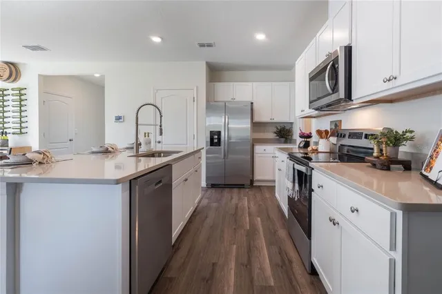a kitchen with stainless steel appliances granite countertop a sink a stove and a refrigerator