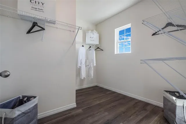 a view of a room with wooden floor and a ceiling fan